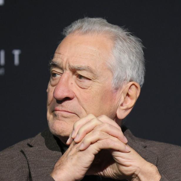 Robert De Niro blickt mit verschränkten Händen nachdenklich zur Seite.