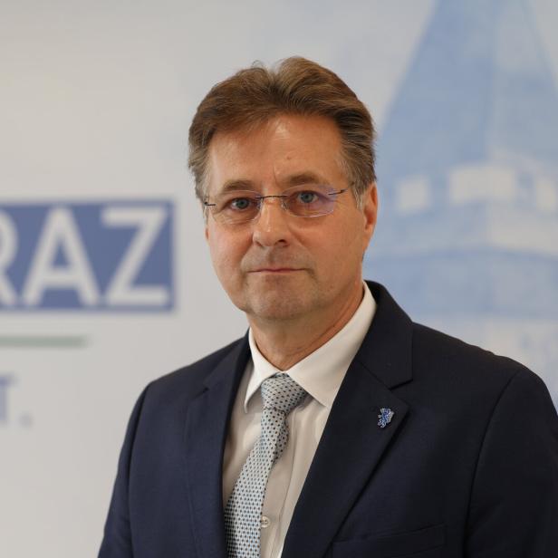 Mann im dunklen Anzug vor Plakat