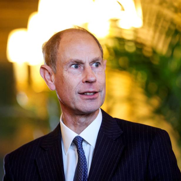 Prinz Edward, in Anzug und Krawatte, blickt aufmerksam zur Seite.