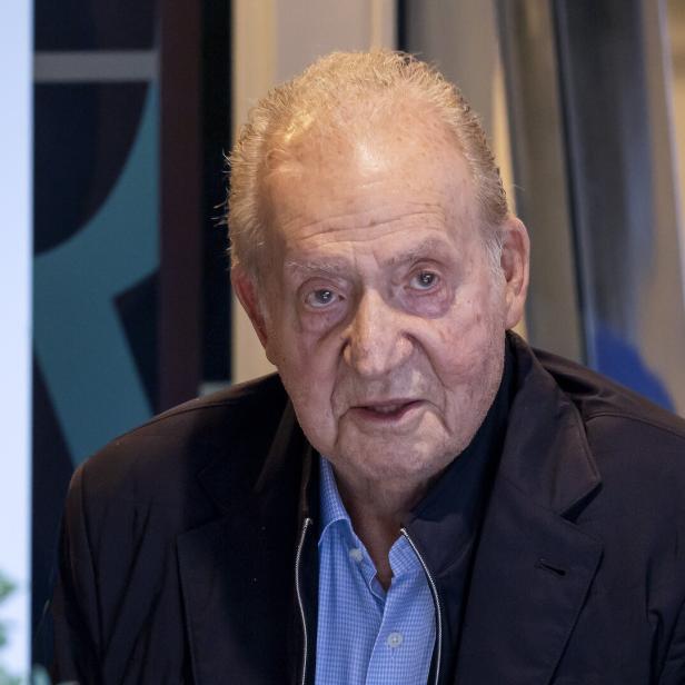 Spaniens Altkönig Juan Carlos trägt ein blaues Hemd unter einem dunklen Sakko.
