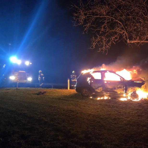 Brennendes Auto bei einem Baum