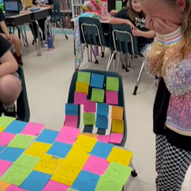 Grundschülerin steht vor Tisch voll bunter Post-its und weint