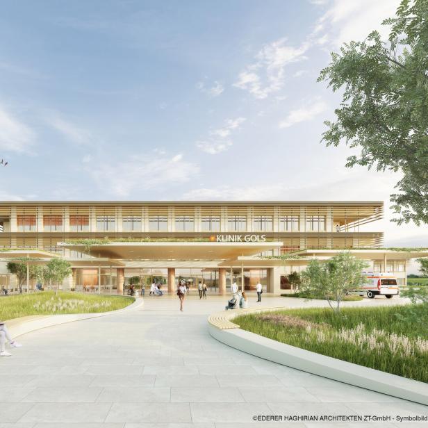 Modernes Klinikgebäude mit großen Glasfronten, umgeben von Grünflächen, Menschen sitzen und gehen auf dem Vorplatz.