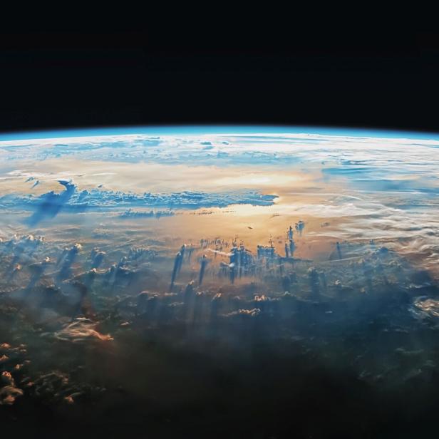 Die Erde ist aus dem Weltraum mit Wolken und Sonnenstrahlen zu sehen.