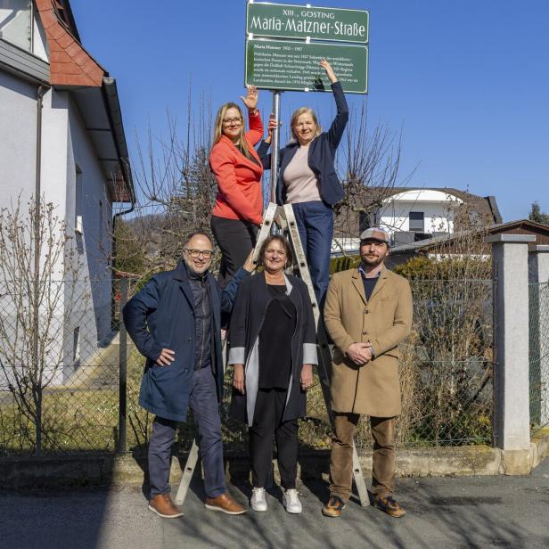 Eine Gruppe von fünf Personen posiert vor dem Straßenschild "Maria-Matzner-Straße" in XIII., Gosting.
