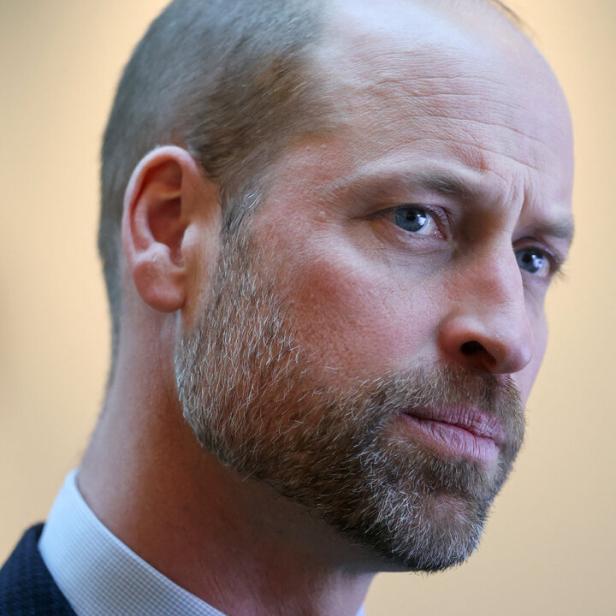 Prinz William mit kurzem Haar und Bart trägt Anzug und Hemd, sein Gesichtsausdruck wirkt nachdenklich.