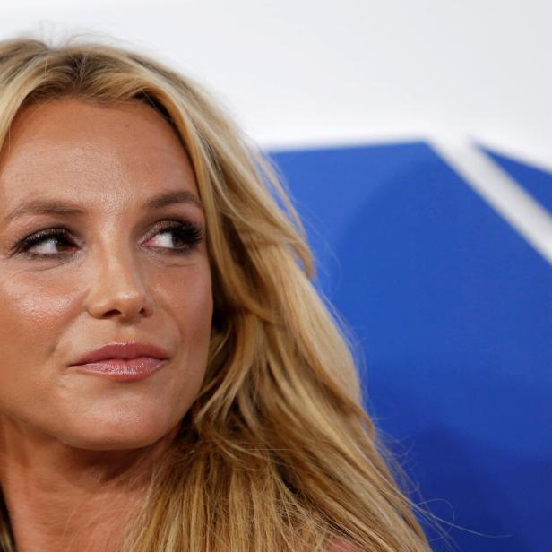 Britney Spears blickt mit blonden Haaren und Ohrring nach rechts.