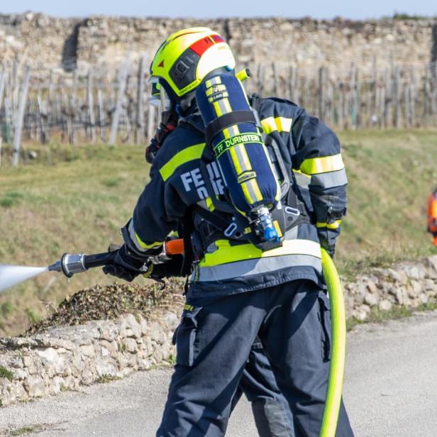 Eine Feuerwehrperson von hinten bei den Löscharbeiten.