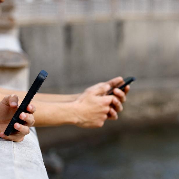 FILE PHOTO: Two 15-year-olds use social media on their mobile phones in Arinaga, on the island of Gran Canaria