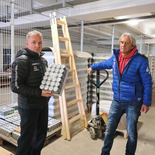 Zwei Männer stehen in einer Lagerhalle