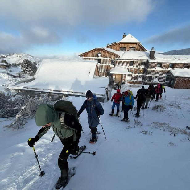 Hütte in den Bergen, Schneeschuhwanderer im vordergrund