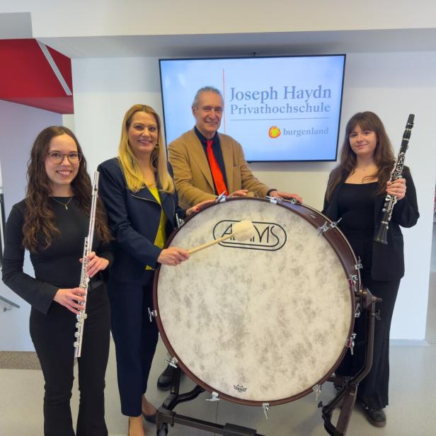 Vier Personen stehen mit einer großen Trommel, einer Querflöte und einer Klarinette in einem modernen Innenraum.