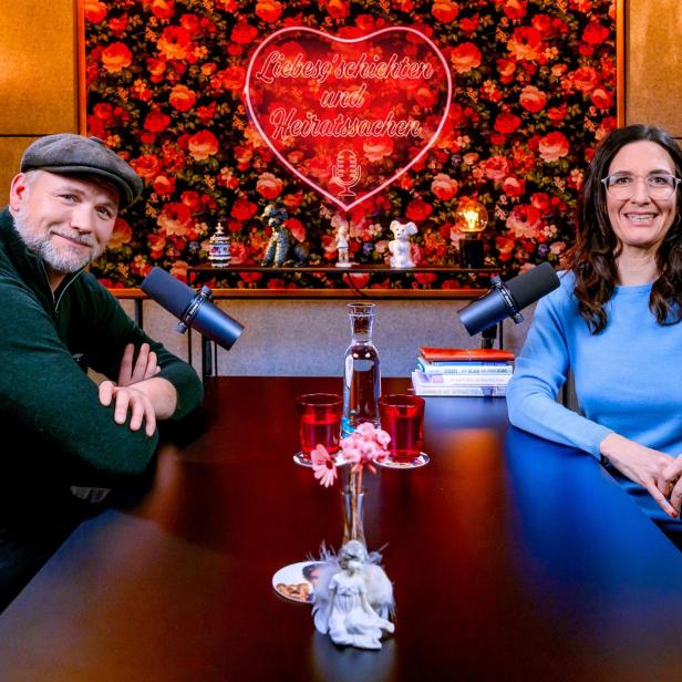 Thomas Stipsits und Nina Horowitz sitzen einander im Podcast-Studio gegenüber