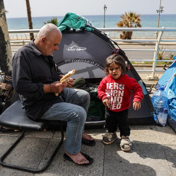 Displaced civilians set up tents along a roadside by the sea, following an escalation between Hezbollah and Israel, in Beirut