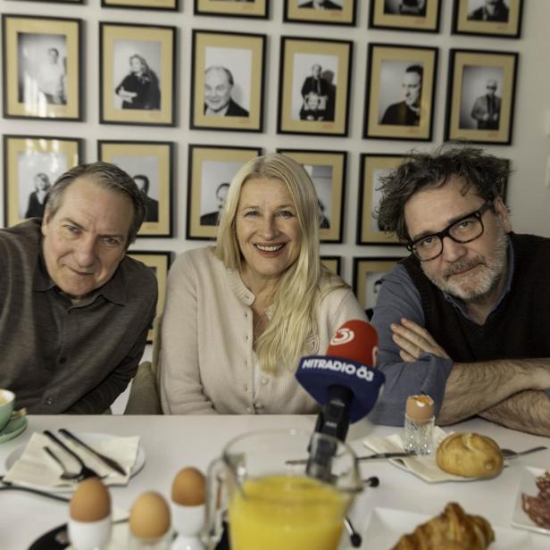 Drei Menschen sitzen an einem Frühstückstisch