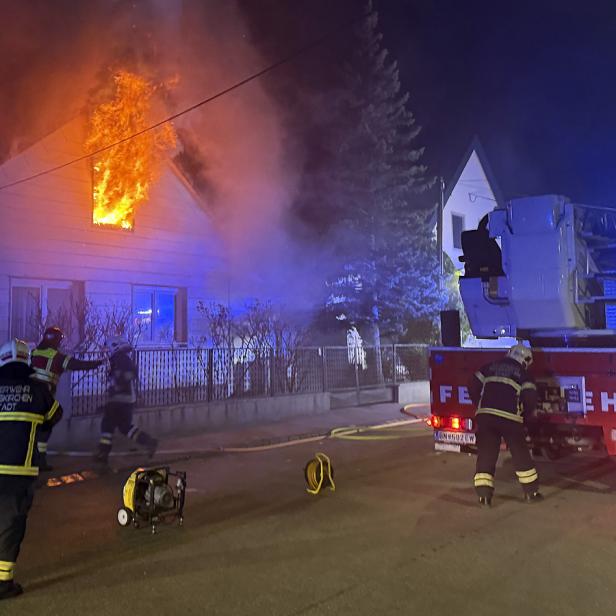 Eine Aufnahme der Feuerwehr vor dem Einfamilienhaus, aus dessen Fenster Flammen schlagen.