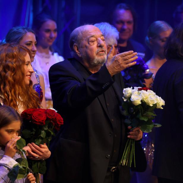Auf der Bühne stehen Darsteller mit Blumensträußen, Ralph Siegel gestikuliert ins Publikum.