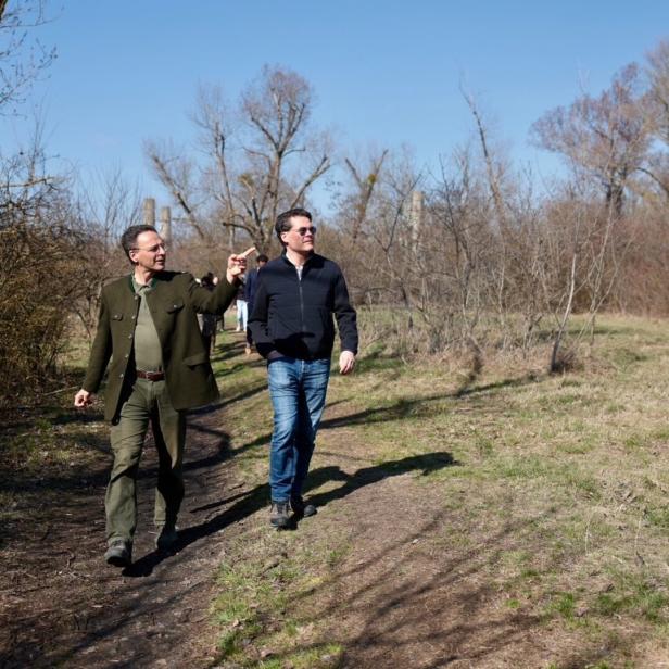 Alexander Mrkvicka und Jürgen Czernohorszky spazieren auf einem Pfad durch eine herbstliche Landschaft.