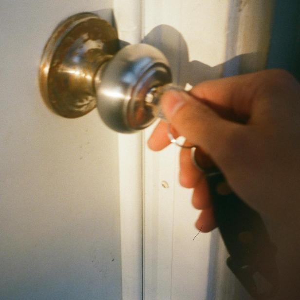 Person, die Wohnungstüre aufsperrt