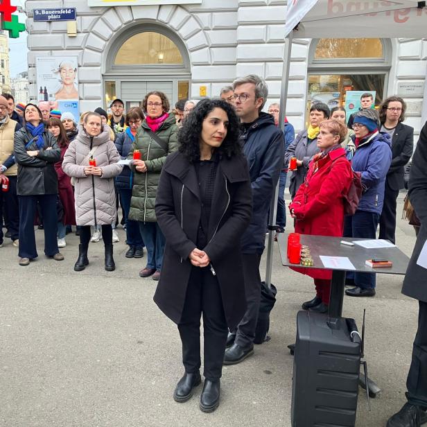 Menschen versammeln sich mit Kerzen zu einer Gedenkveranstaltung am Bauernfeldplatz.