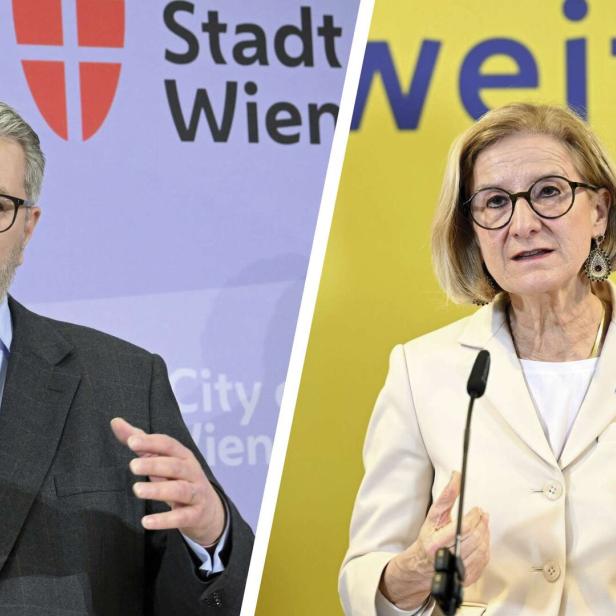 Peter Hacker und Johanne-Mikl-Leitner sprechen jeweils vor Mikrofonen, beide tragen Brillen und helle Sakkos, hinter ihnen farbige Hintergründe mit Schrift.