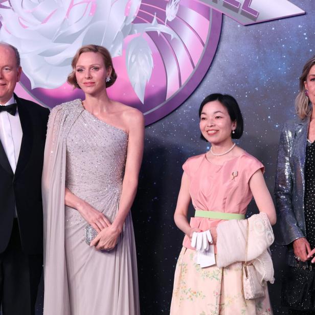 Fürst Albert II., Charlène von Monaco und Caroline posieren vor einem Hintergrund mit Weltraummotiv.