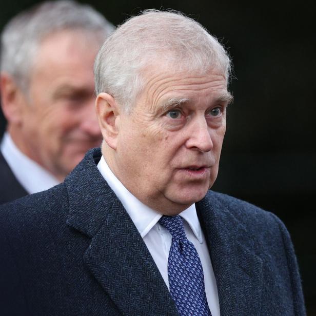 Andrew Mountbatten-Windsor trägt einen dunklen Mantel und eine blaue Krawatte mit Muster.