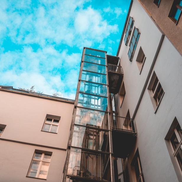 glass elevator at apartment house with fluffy background sky