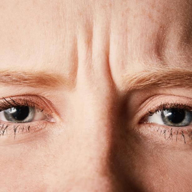 Beautiful but frowning young redhead in cropped close-up