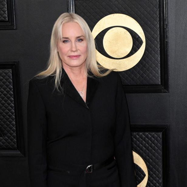 Daryl Hannah mit blonden Haaren trägt einen schwarzen Blazer und eine gestreifte Strumpfhose.
