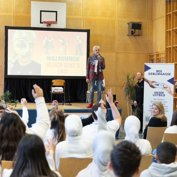 Thomas Brezina auf der Bühne, mehrere Jugendliche im Publikum zeigen auf. 