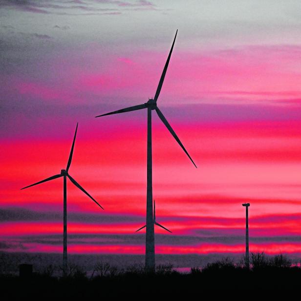 Windräder vor rotem Himmel.