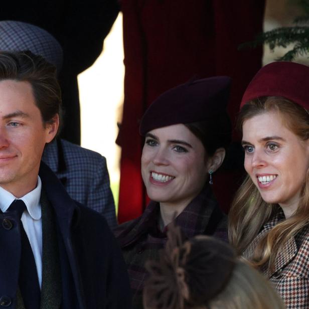 Drei lächelnde Personen, darunter Prinzessin Beatrice und Prinzessin Eugenie mit Hüten, sind zu sehen.