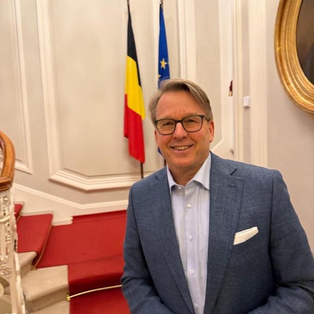 Serge Falck vor der belgischen und der europäischen Flagge