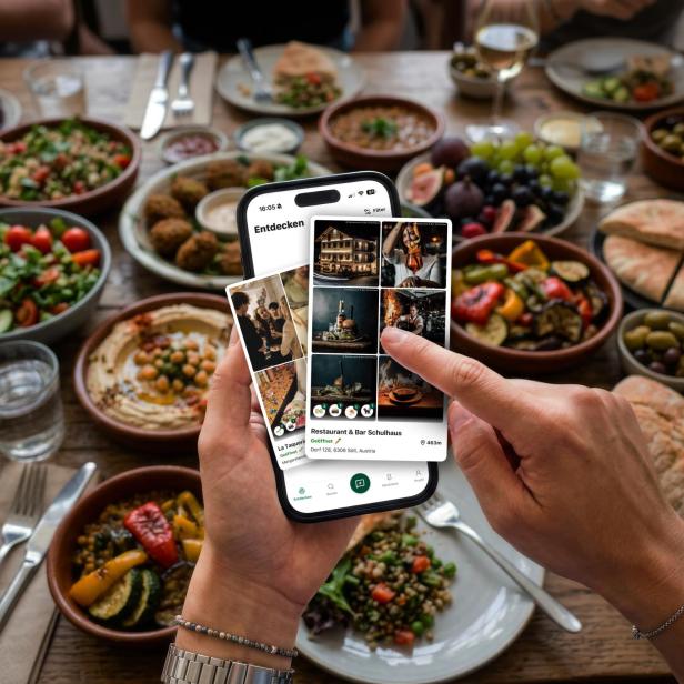 Handy mit Bildern vor mit Essen gefülltem Tisch