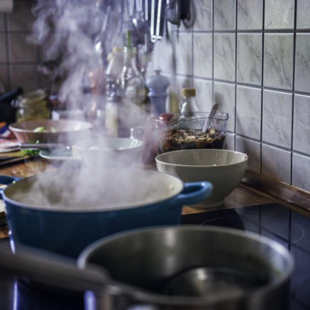 Auf dem Herd blubbert es in mehreren Töpfen und Wasserdampf steigt auf