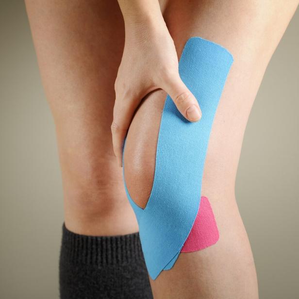 Kinesiotape auf einem Knie.
