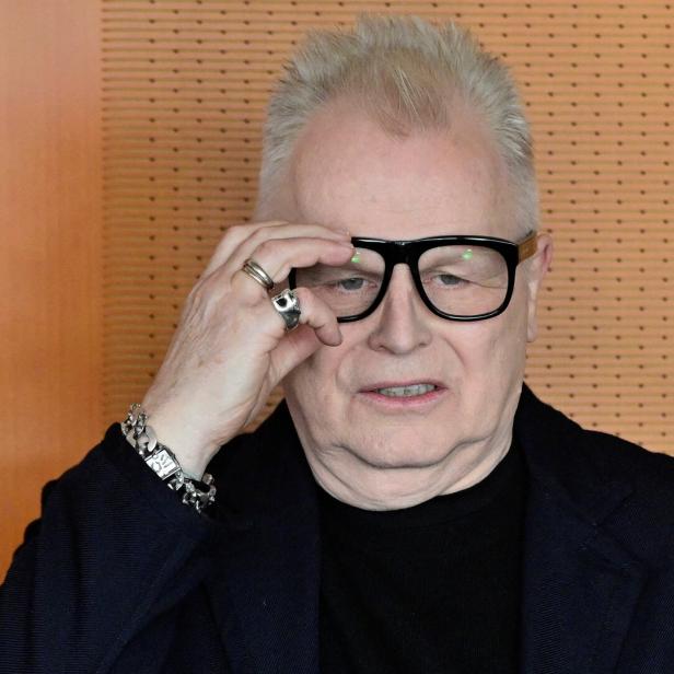 Herbert Grönemeyer mit Brille und Schmuck blickt nachdenklich in die Kamera.