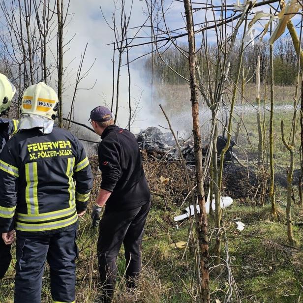 Feuerwehr löscht Wrack in einem Wald