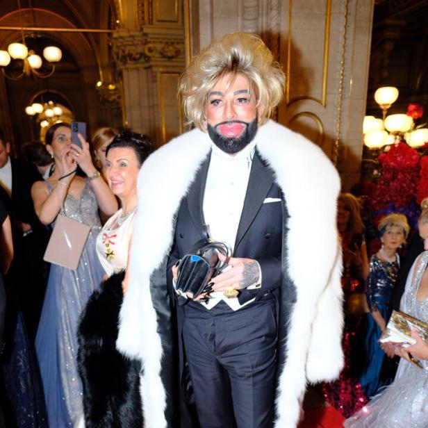 Harald Glööckler im Smoking mit Pelzmantel auf dem roten Teppich.
