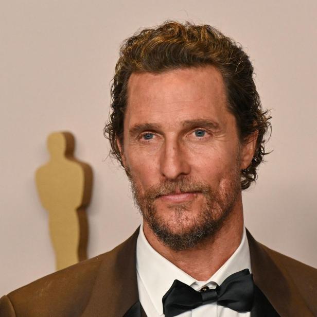 Matthew McConaughey trägt Fliege und braunen Anzug vor hellem Hintergrund.
