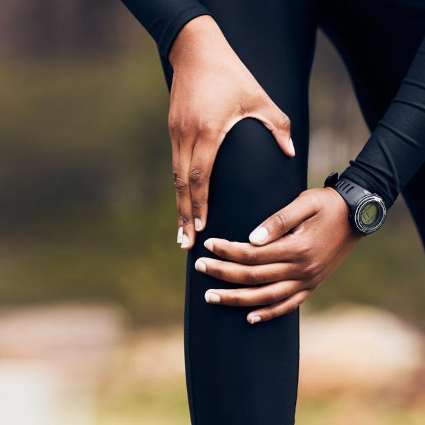 Eine Frau greift sich ans Knie.