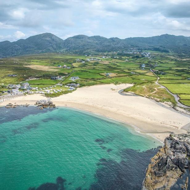 Türkises Meer, weißer Strand, grüne Felder