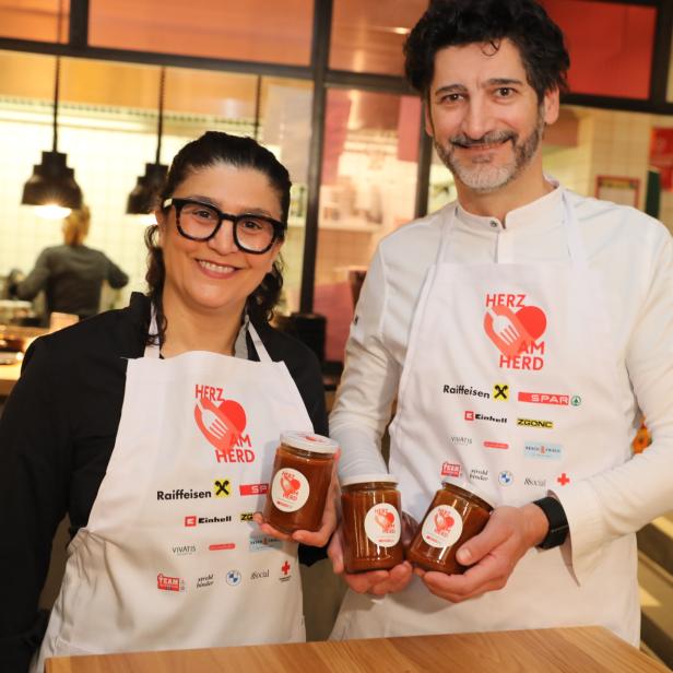 Parvin Razavi und Paul Ivic mit Schürzen und Marmeladengläsern in den Händen