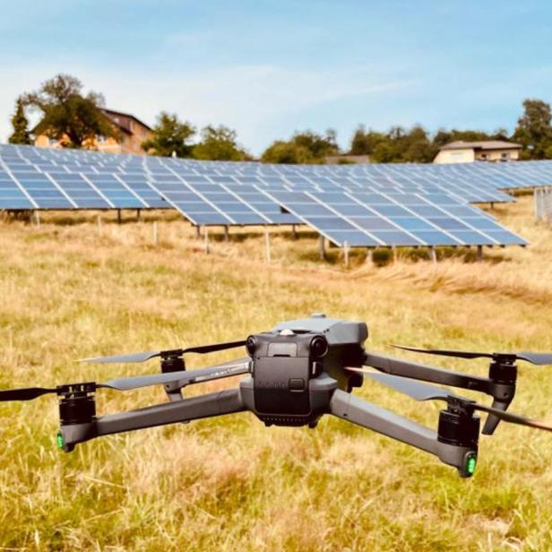 Eine Drohne fliegt über PV-Anlagen 
