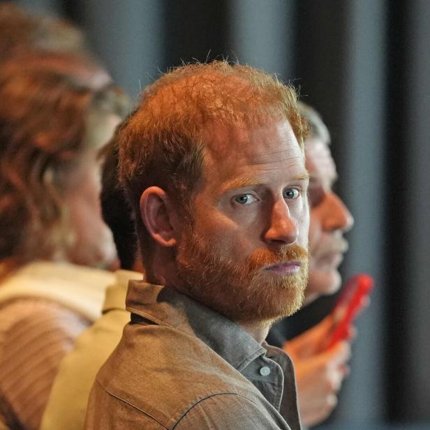 Prinz Harry blickt aufmerksam, mit Bart und rötlichem Haar, in die Ferne.