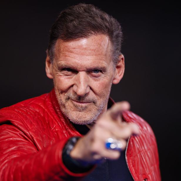 Ralf Möller in roter Lederjacke zeigt mit dem Finger direkt auf den Betrachter.