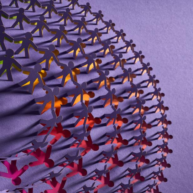 Colorful interconnected paper chain of human figures forming a spiraling design symbolizing unity and diversity.