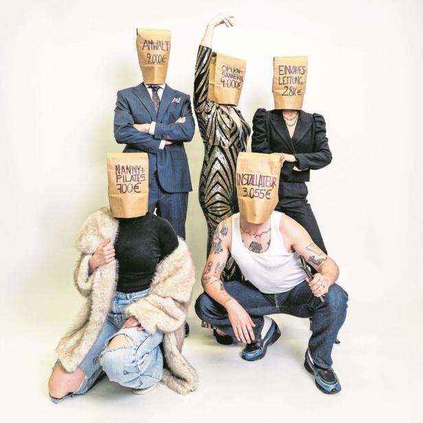 Fünf Personen mit Papiertüten über dem Kopf, auf denen verschiedene Berufe und Monatsgehälter geschrieben stehen.