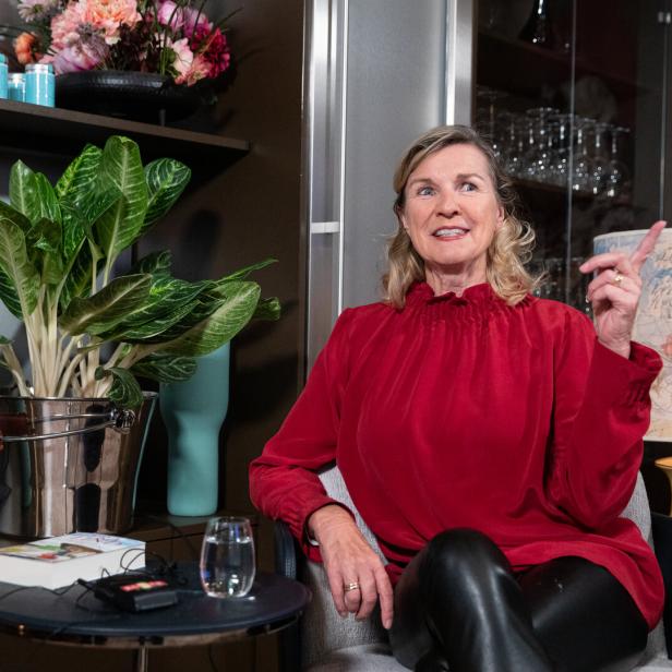 Hera Lind sitzt und gestikuliert beim Sprechen.